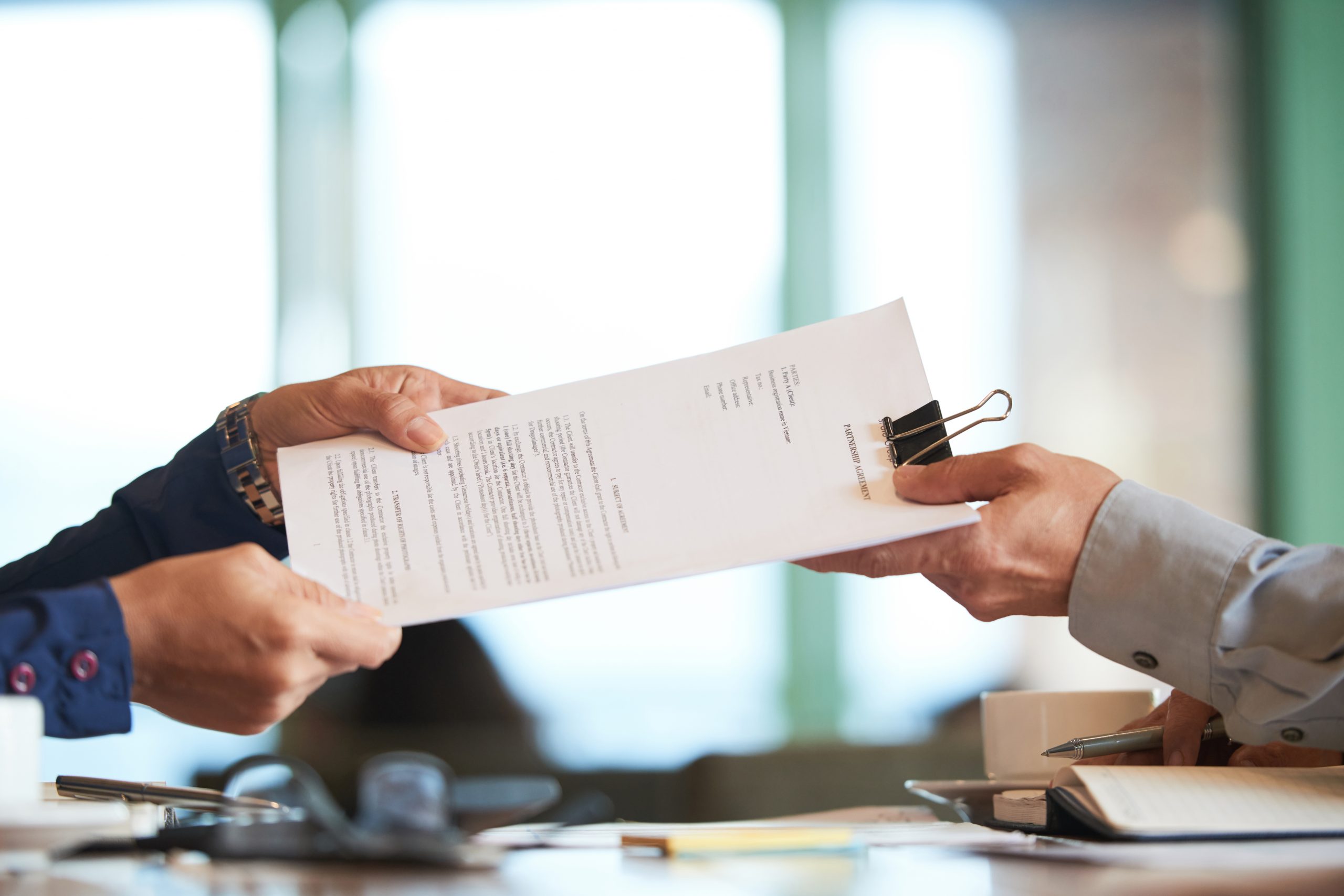 Business person giving partnership agreement to coworker